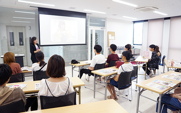 オープンキャンパス参加者にプロジェクターで説明をおこなう様子